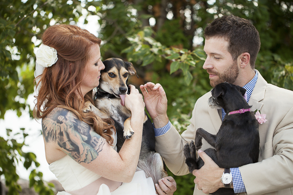 beautiful redhead bride with tattoos, dogs, groom in gingham shirt, holding dogs