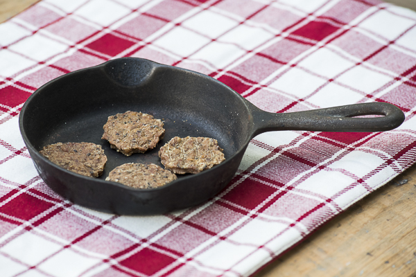 Dog treats in skillet, Sizzlers in skillet on red plaid runner