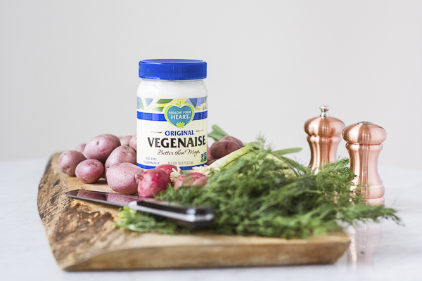 ingredients for vegan potato salad on rustic wood cutting board