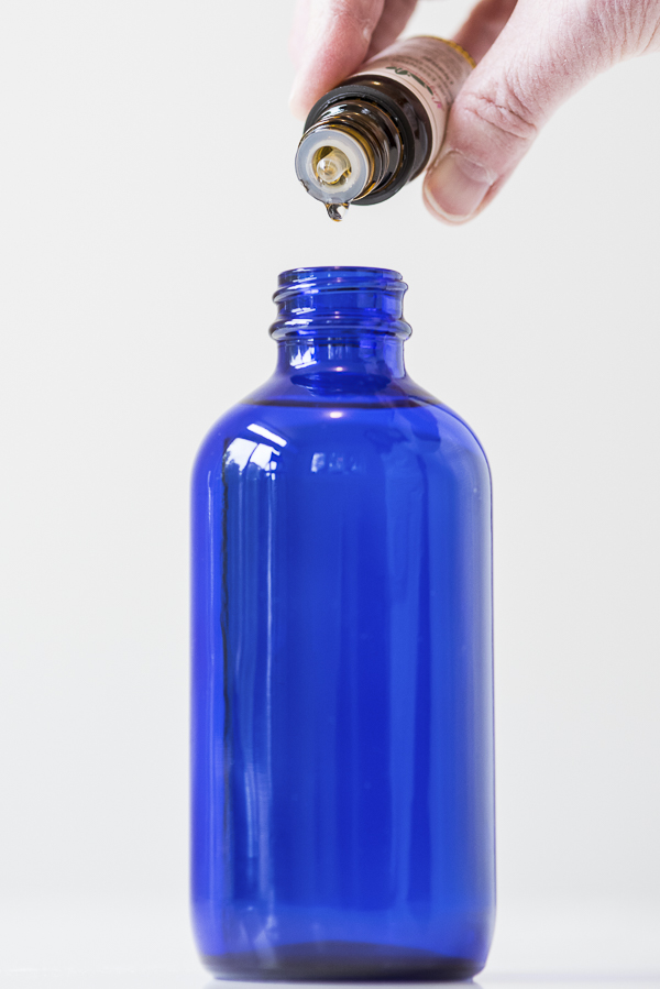 adding essential oil to cobalt blue bottle