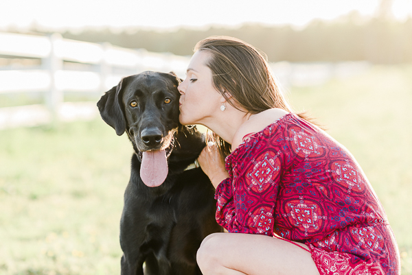 young woman kissing handsome black lab, on location dog photography