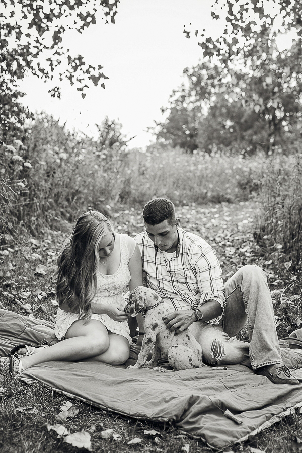 couple and puppy on blanket in wildflowers