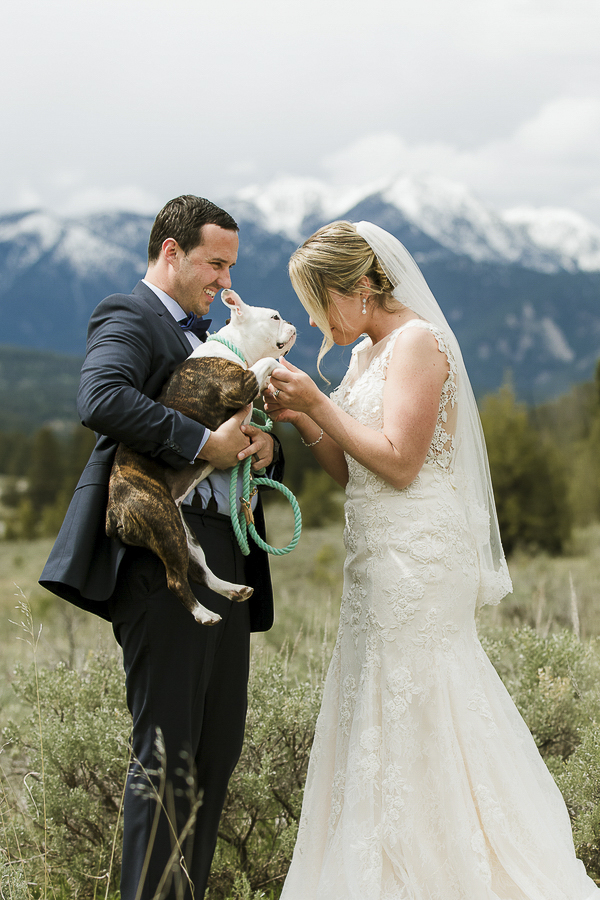 groom holding dog, bride looking at dog, wedding dog, Rocky Mountains in background ©Elements of Light Photography