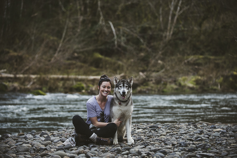Malamute and her person sitting on riverbank rocks, Oregon,, lifestyle dog photography ©Laurie Jean Photography