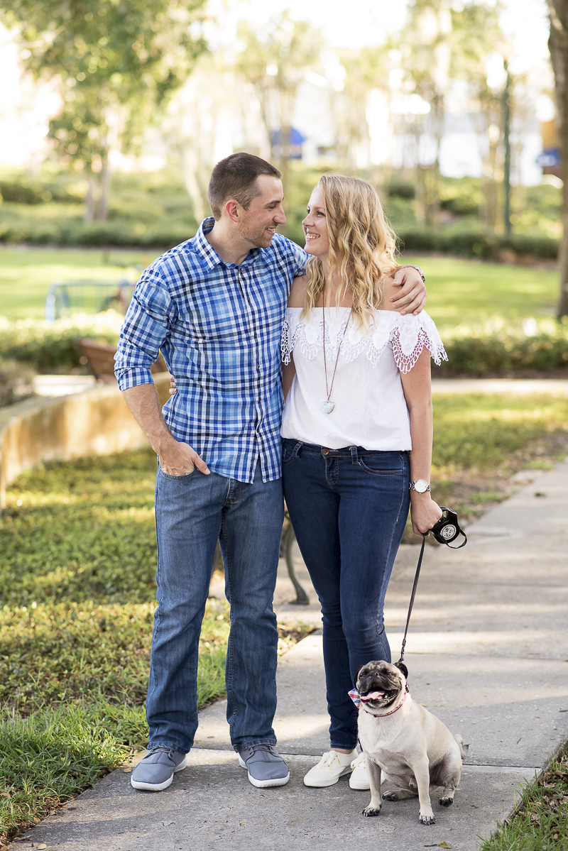 couple looking at each other, dog sitting on sidewalk, ©Corner House Photography | Central Florida dog friendly engagement session