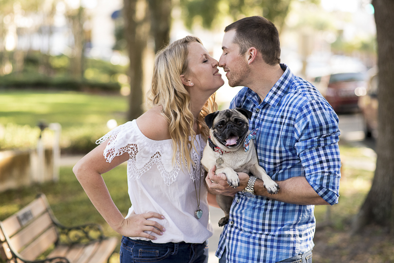 ©Corner House Photography | Central Florida dog friendly engagement session, couple almost kissing while holding Pug