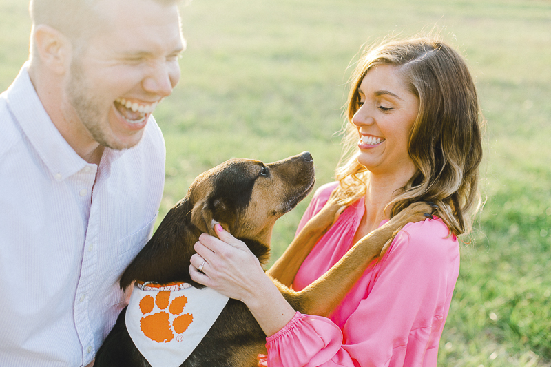 dog wearing bandanna with orange paw print hugging woman, ©Casey Hendrickson Photography | Charlotte, NC Engagement photos with mixed breed dog