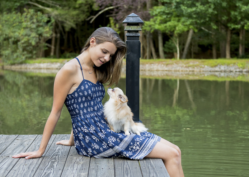 bond between dog and human, long haired Chi sitting in teen's lap on dock ©Trina Bauer Photography | Dog-Friendly senior portraits