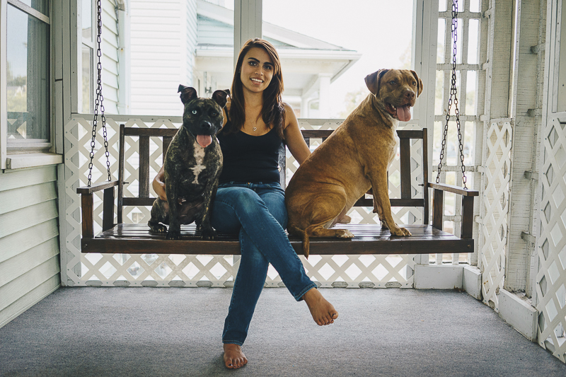woman sitting on porch swing with her dogs, lifestyle dog photography, ©Heck Designs and Photography