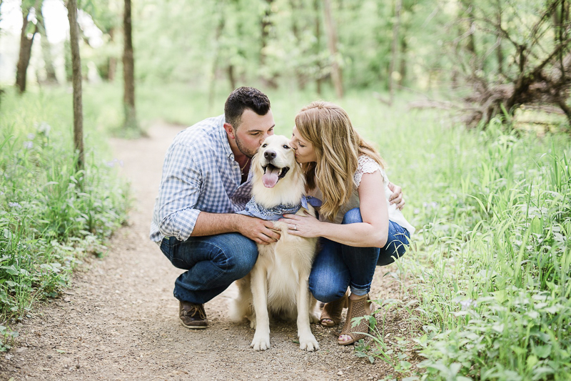 couple kneeling down and kissing their Golden Retriever, ©Zoe Life Photography | dog friendly engagement photos with Golden Retriever, Castlewood State Park, MO