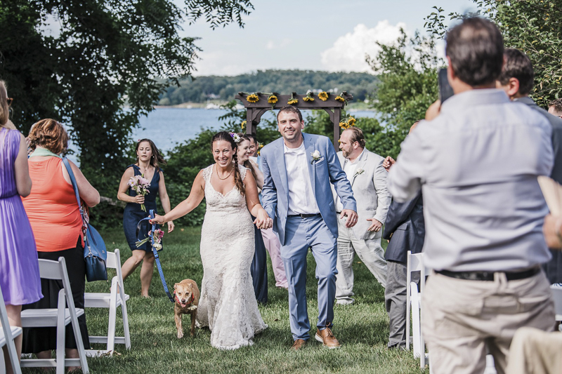 Just married bride, groom and dog walking up the aisle