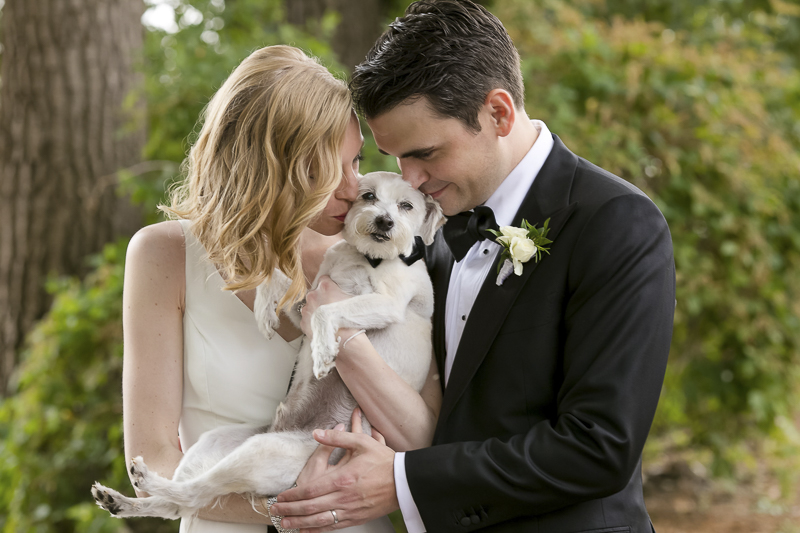bride and groom kissing their dog | wedding photos with dogs, ©Jeannine Marie Photography -dog-friendly wedding photographer