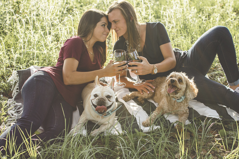 two women toasting to their future, summer engagement photos with dogs | ©Kimberly Santana Photography