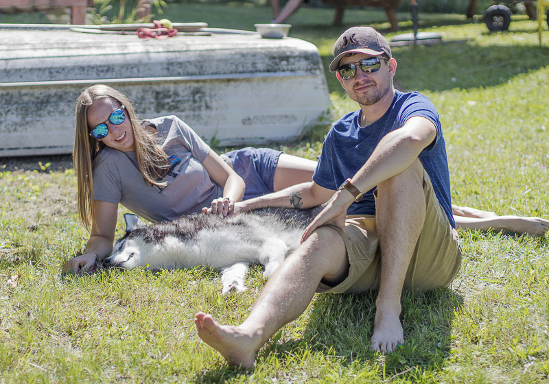 couple and their dog lying on the grass | ©Salute Life Photography, Fort Drum, NY, lifestyle dog photography