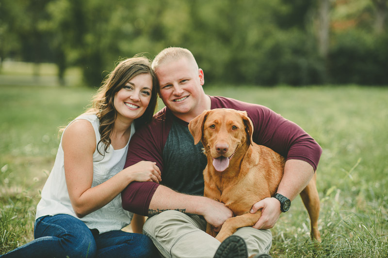 couple sitting on grass with Red Labrador Retriever, ©Kate Spencer Photography