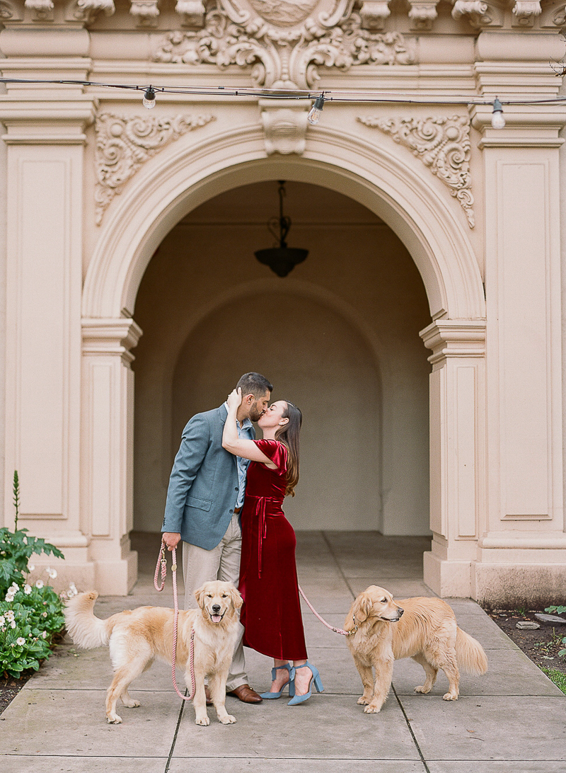 couple kissing in Balboa Park, dog-friendly engagement photos | ©The Ganeys