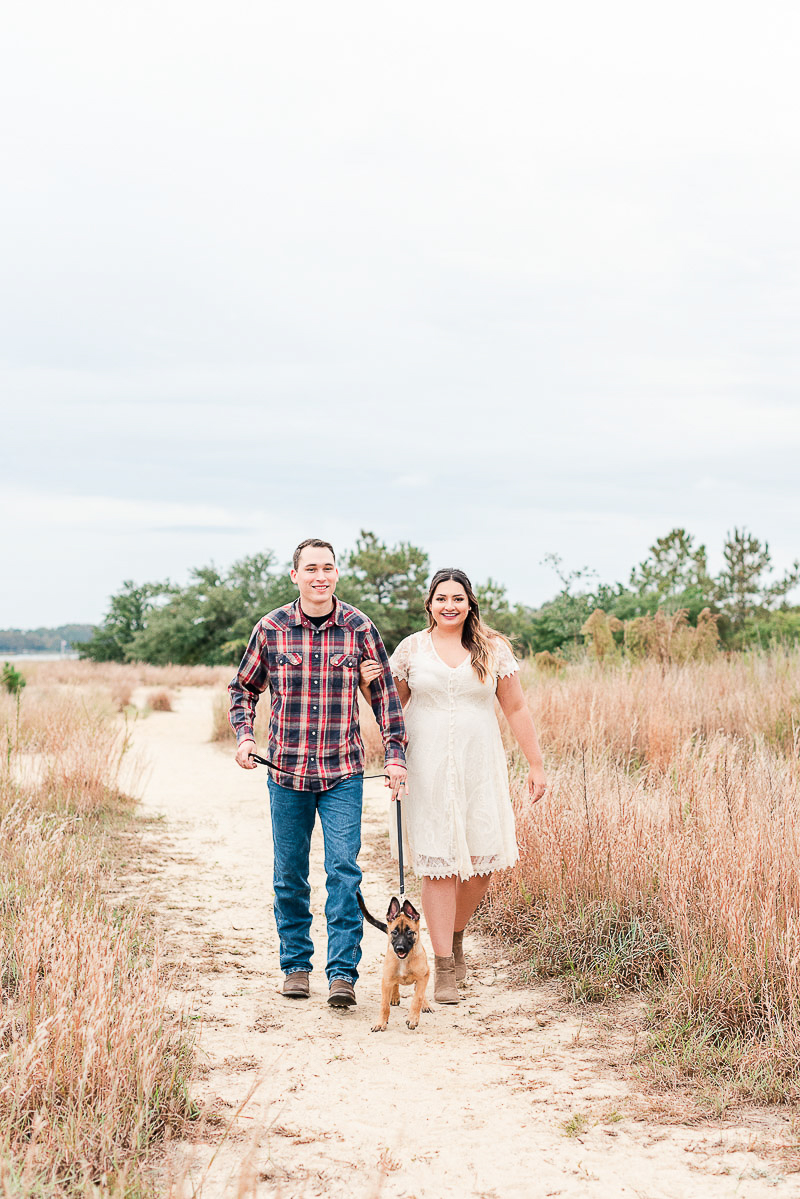 couple walking their puppy on sandy trail, Pleasure House Point, Virginia Beach | ©Catherine Crane Photography | pet photography