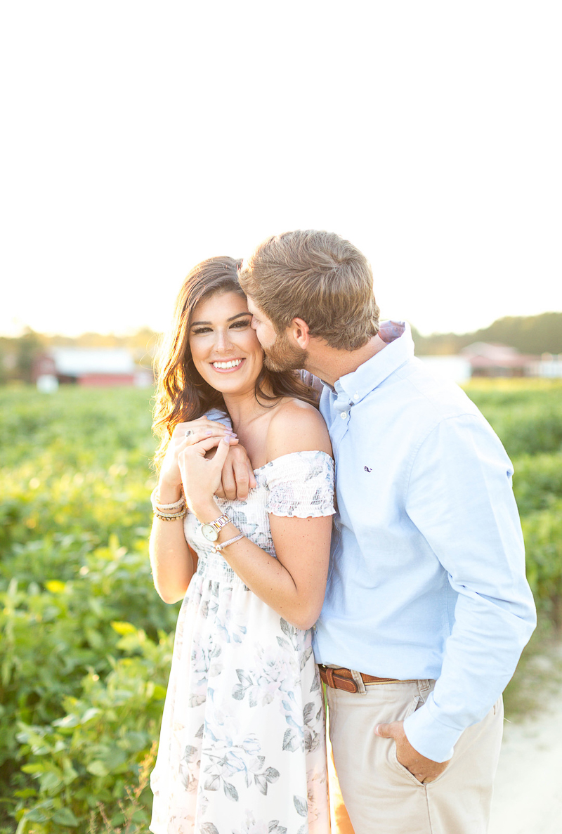 man kissing woman in farmer's field, ©Brynn Gross Photography