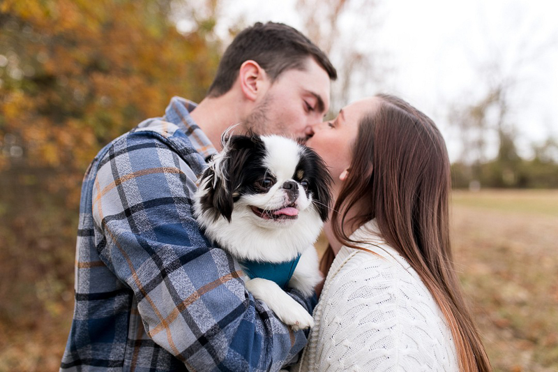 man holding Japanese Chin and kissing woman, dog-friendly engagement session | ©Autumn Howell Photography 