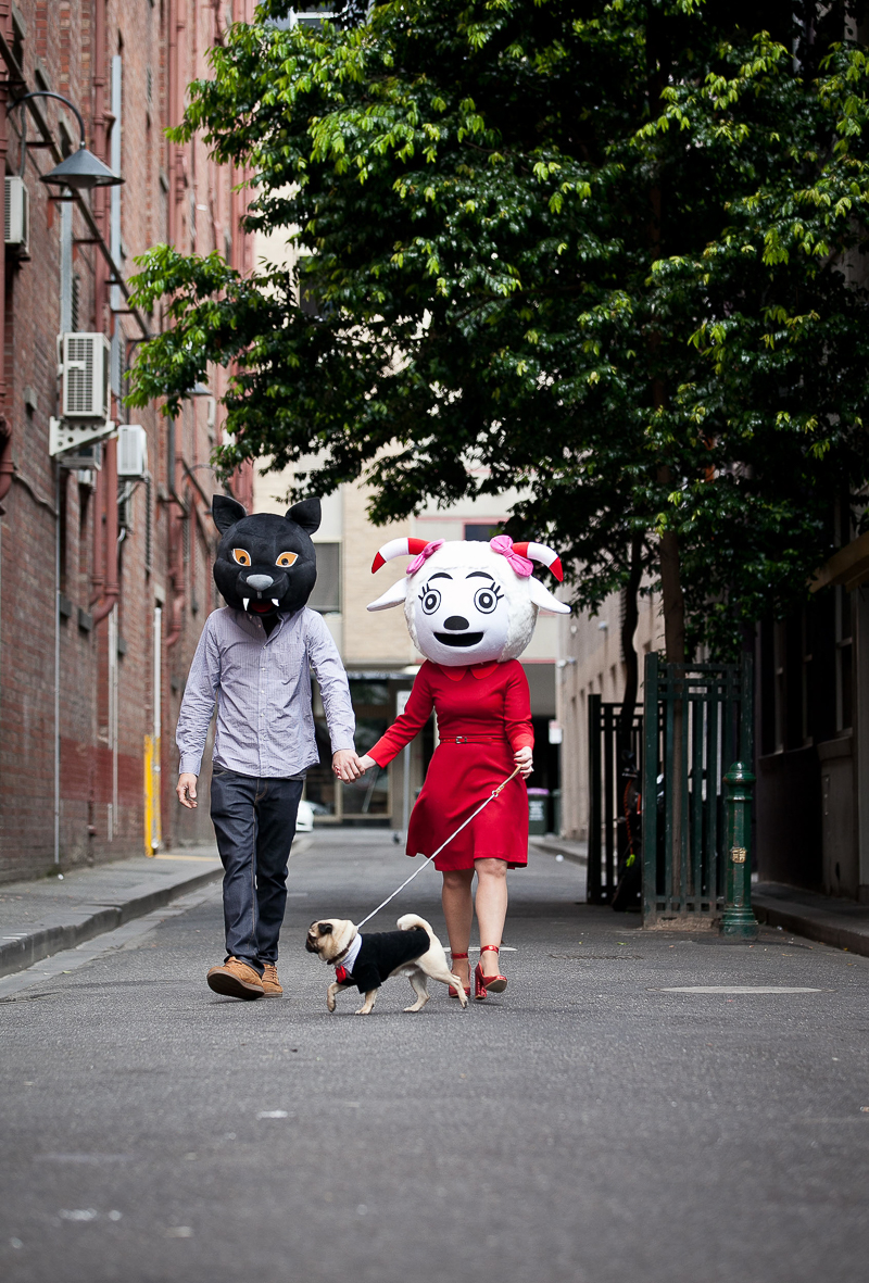 couple wearing big animal heads walking their dog, quirky engagement photos | ©Pupparazzi Pet Photography