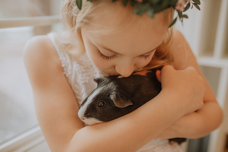 girl kissing her guinea pig, ©Gardenhouse FIlms | pet-friendly first communion session, Albany, NY