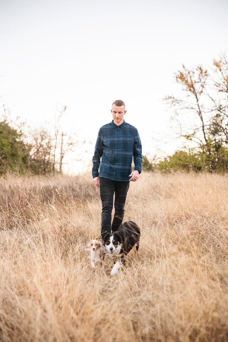 man walking through field with dogs, ©Monika Normand Photography | Dallas lifestyle dog-friendly family photography