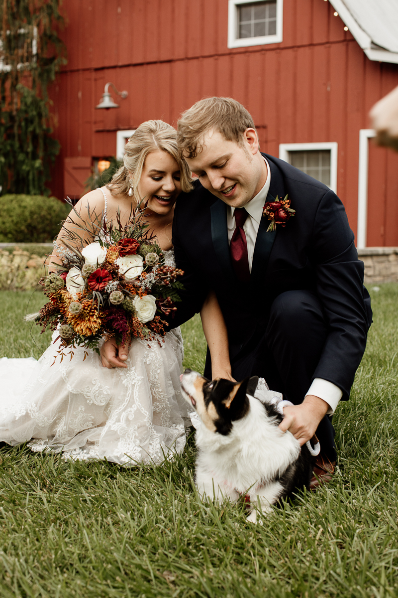 bride holding fall bouquet, groom and their dog | © McKenzie Bigliazzi Photography