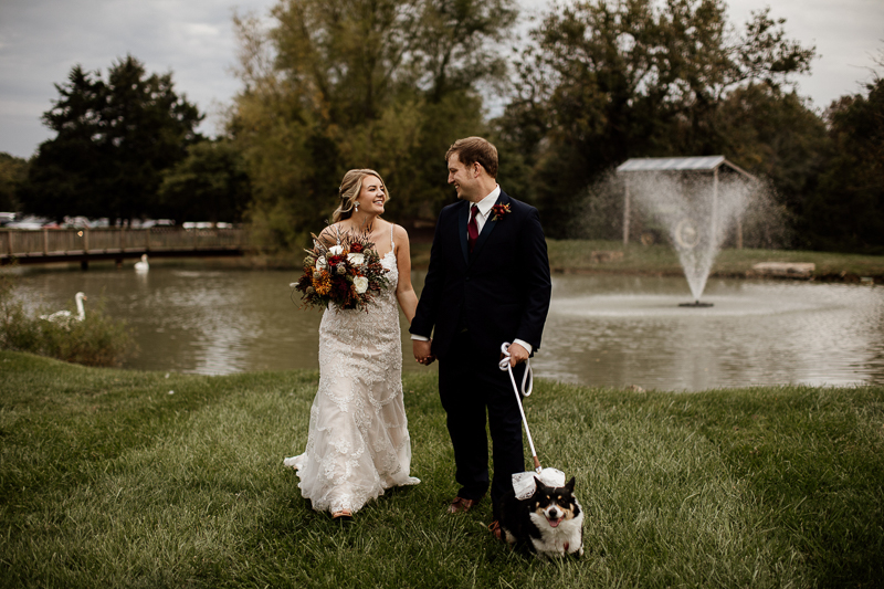 Corgi, bride, and groom in front of swan pond | © McKenzie Bigliazzi Photography, Wright City, MO