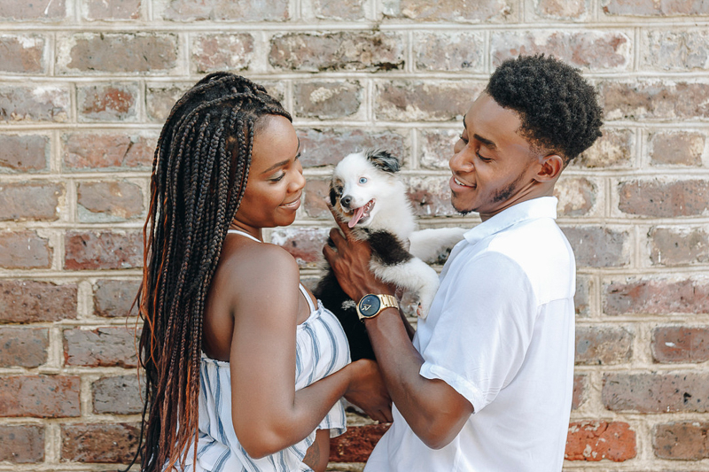 dog-friendly portrait session, couple and puppy in front of brick wall, ©Charleston Photo Art, LLC 
