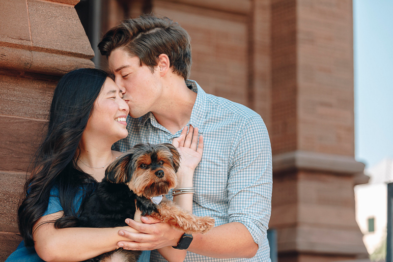 man kissing woman with a Yorkie on her lap ©Charleston Photo Art | Legare Street Engagement Session