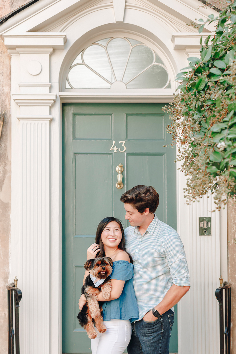couple and their dog in front of sage green door, ©Charleston Photo Art | Legare Street Engagement Session