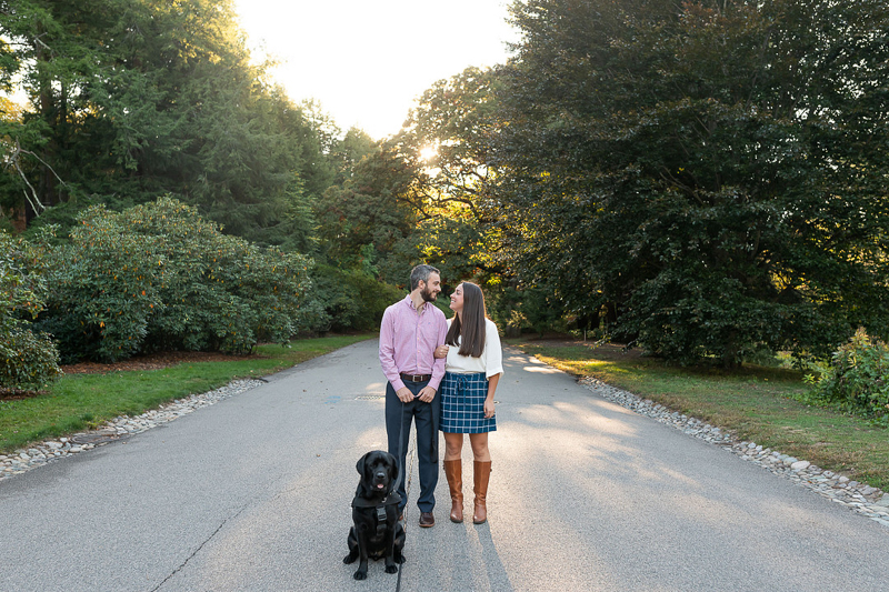 couple standing in the road, dog sitting in front of them, dog-friendly engagement ideas | ©Jess Sinatra Photography | Boston, MA