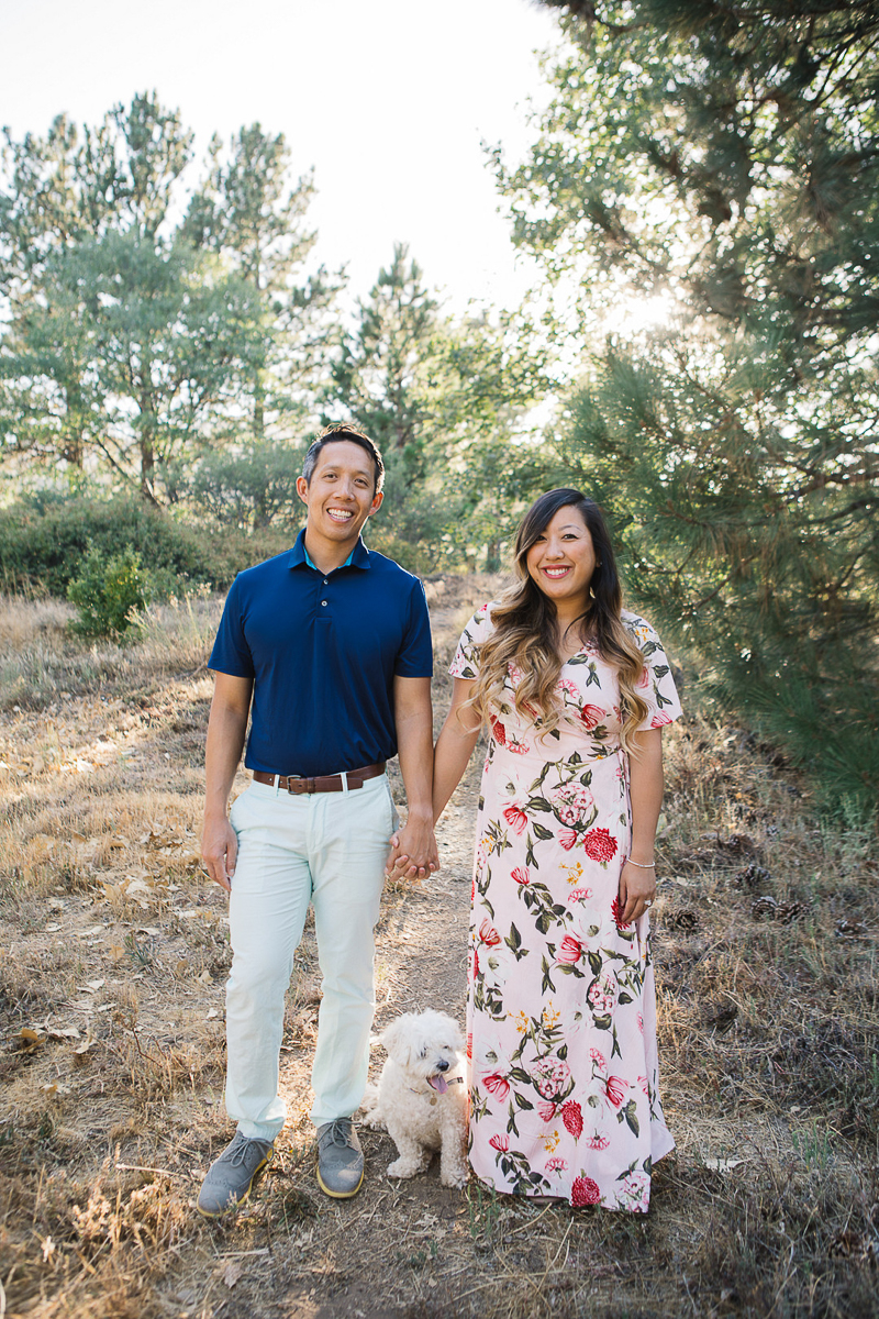 couple holding hands, dog standing between them, dog-friendly engagement photo ideas | ©Stephanie Fong Photography