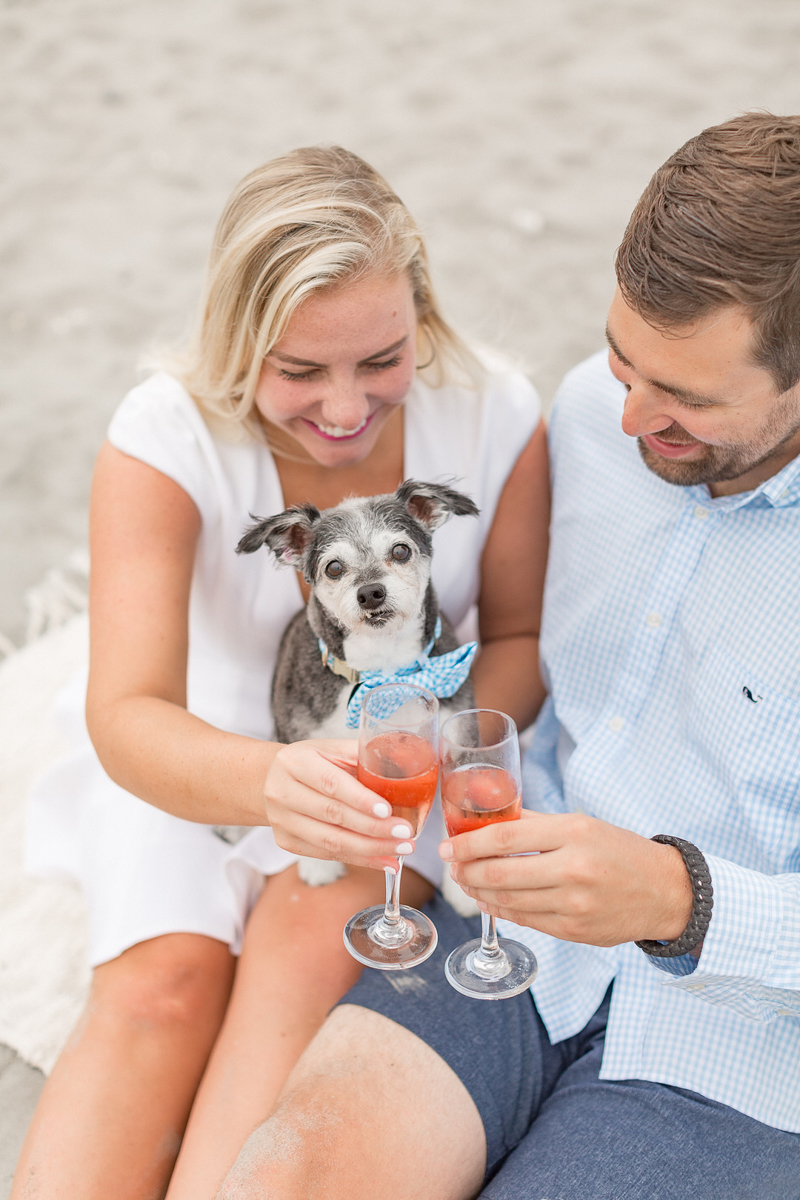 couple making a toast, dog-friendly engagement ideas, beach portraits | ©Coli Michael Photography 