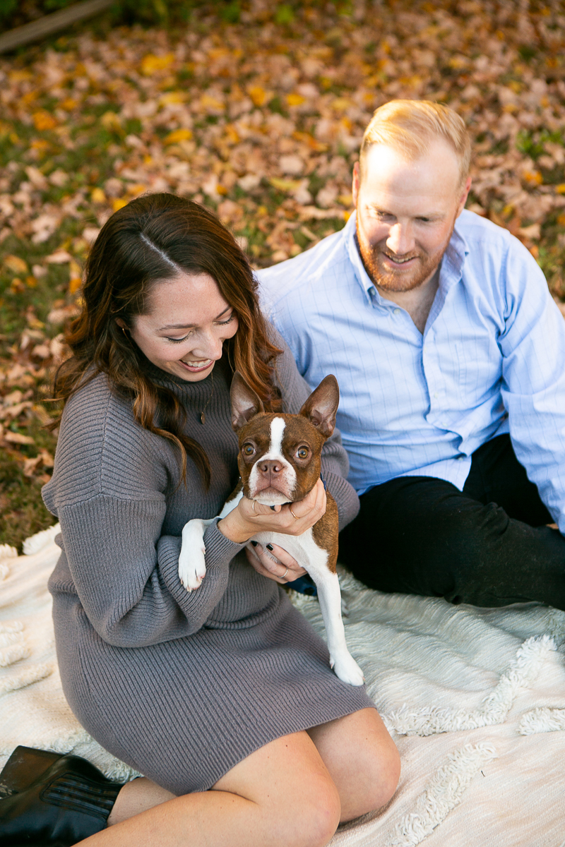 couple sitting on blanket, Boston Terrier in woman's lap, fall photography ideas | ©Mandy Whitley Photography