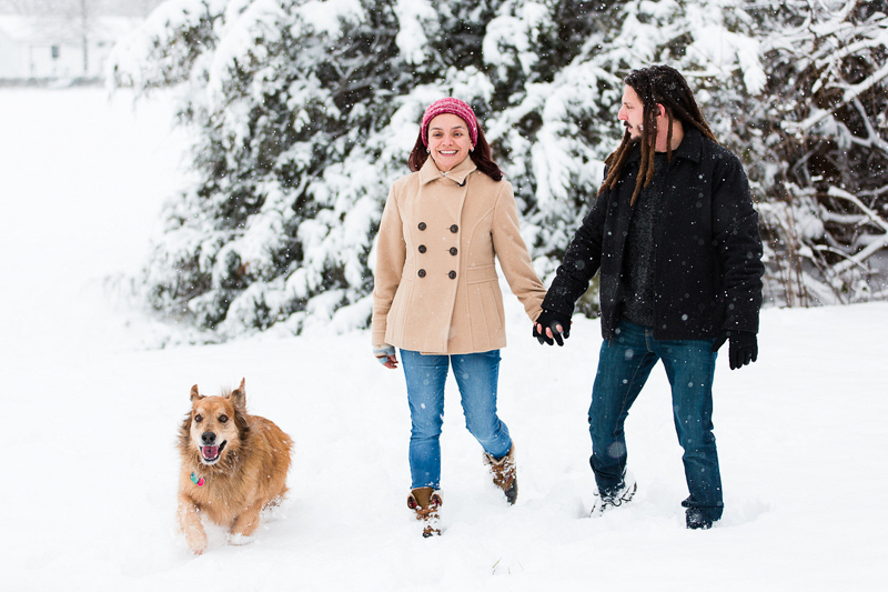 couple holding hands and walking through the snow with their Golden Retriever mix | ©Megan Rei Photography | Bealeton, VA