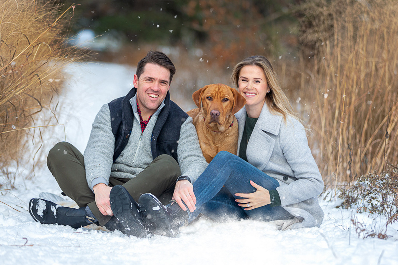 couple sitting on the snow with their Lab mix, dog-friendly family portraits, winter photography ideas | ©Terri J Photography, Toronto, Ontario