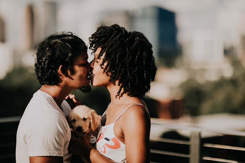 couple kissing while holding their puppy between them | ©Sheena Shahangian Photography 