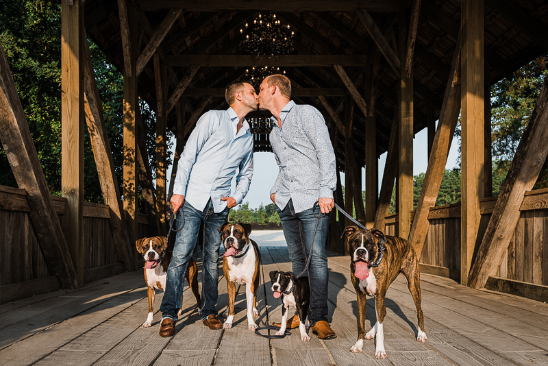 men kissing on covered bridge, dog-friendly engagement ideas, Boxers | ©Melonhead Photography