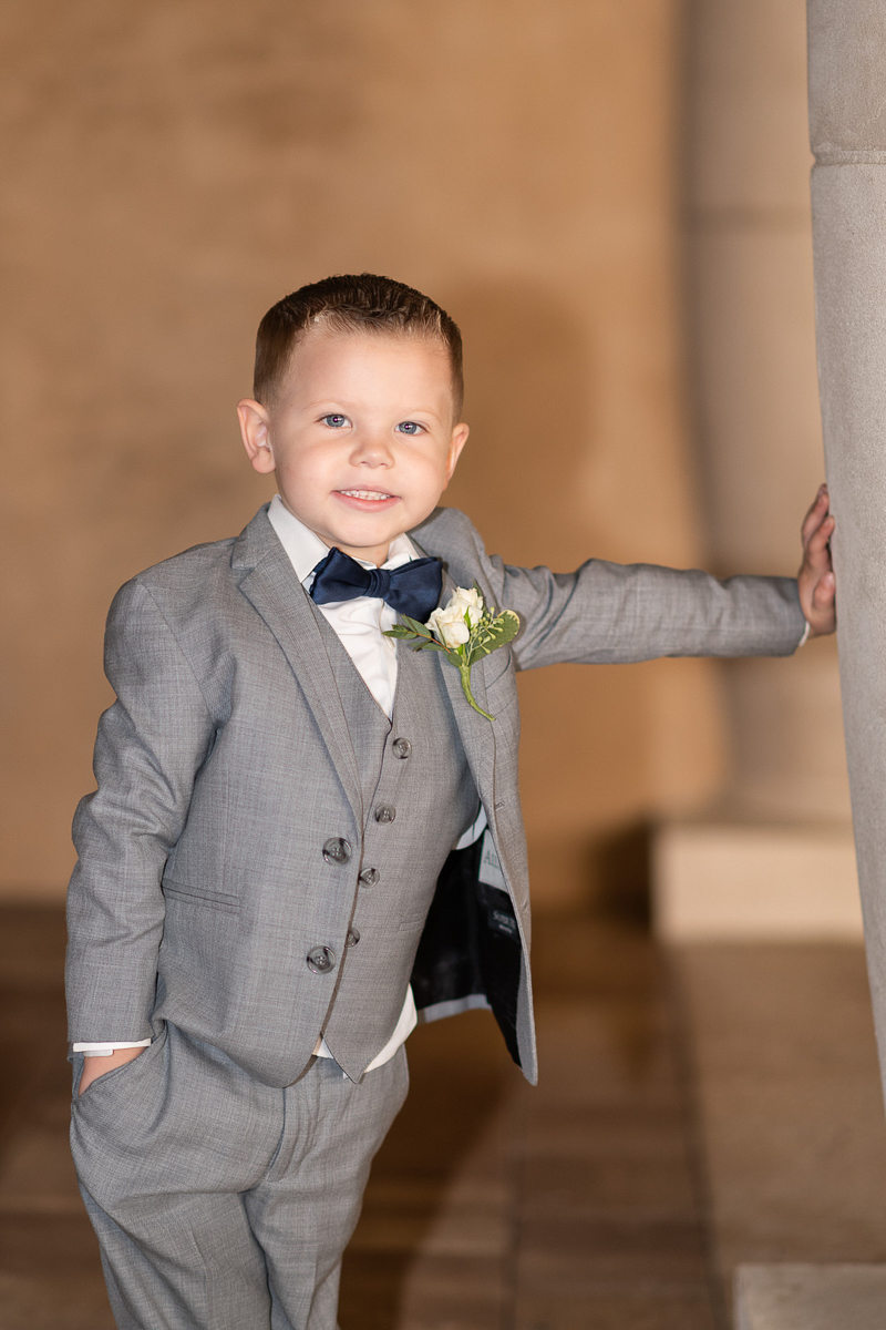 adorable ring bearer wearing gray suit and navy bow tie ©Ryan Smith Photography,