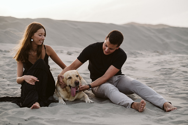 Labrador Retriever and couple sitting on the sand | ©Blancorazon Weddings