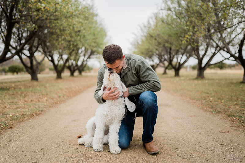 man hugging mini Goldendoodle dog, dog-friendly family photos, Sioux Falls, SD | ©Erica Jane Photography