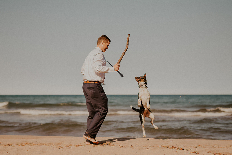 Man playing with dog at Lake Huron, dog-friendly elopement | ©Brittany Hamann Photography