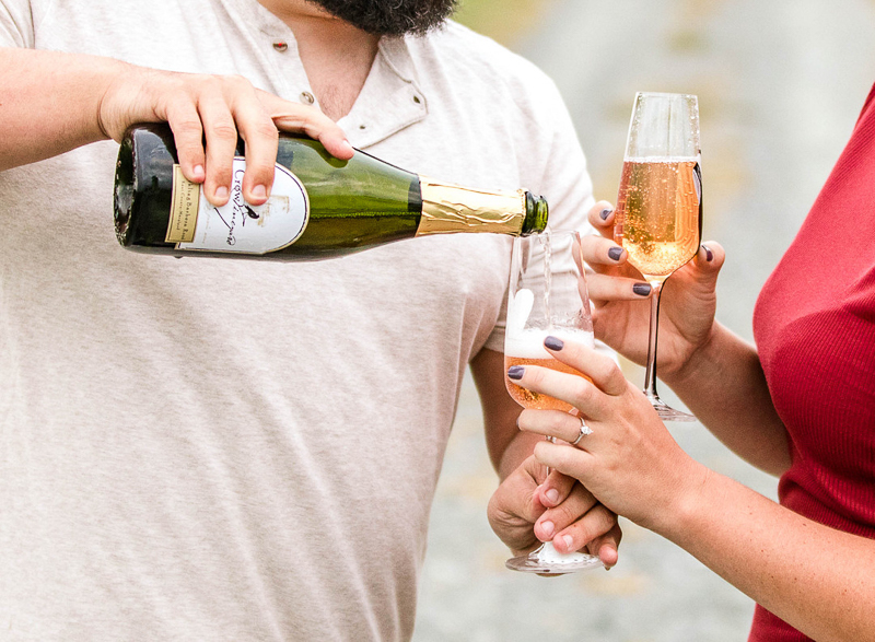 couple holding champagne flutes and pouring sparking rose, Crow Vineyard & Winery | Fox Photography LLC