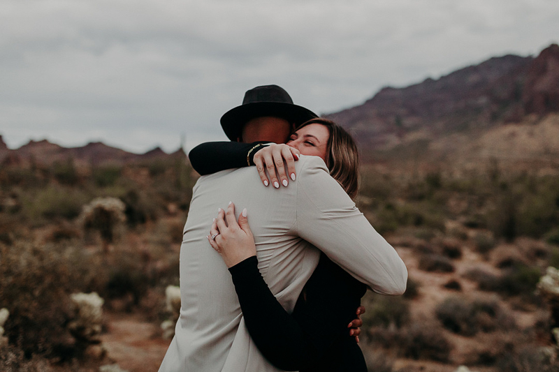 man and woman embracing after marriage proposal, desert photo session