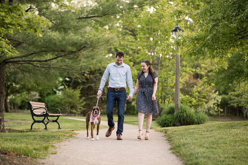 couple holding hands while walking their dog through Sayen Gardens | Creative Image Weddings & Portraits