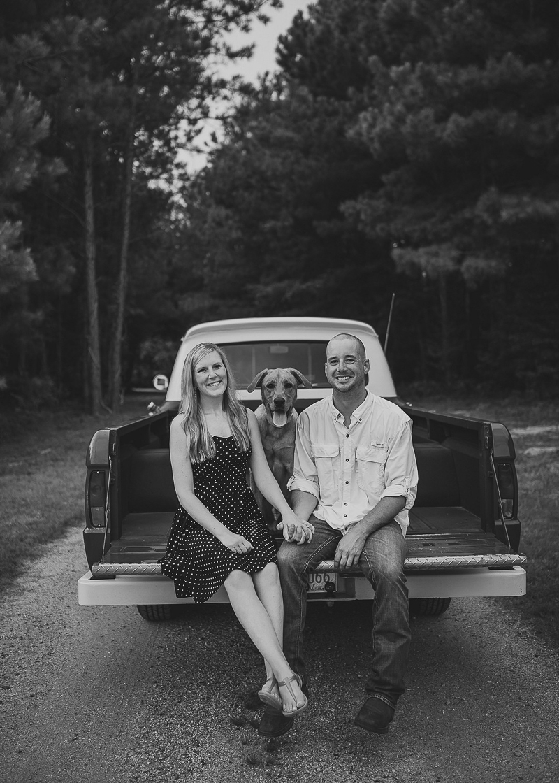 couple holding hands and their dog in back of vintage pickup truck | ©Memories by Lexi