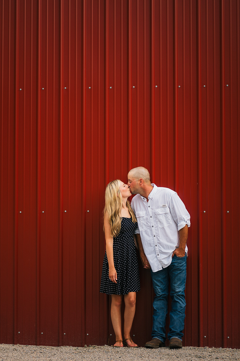 couple kissing in front of red barn | dog-friendly engagement | ©Memories by Lexi
