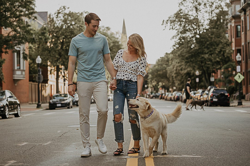 couple walking their dog down a city street | © CityLux Studios