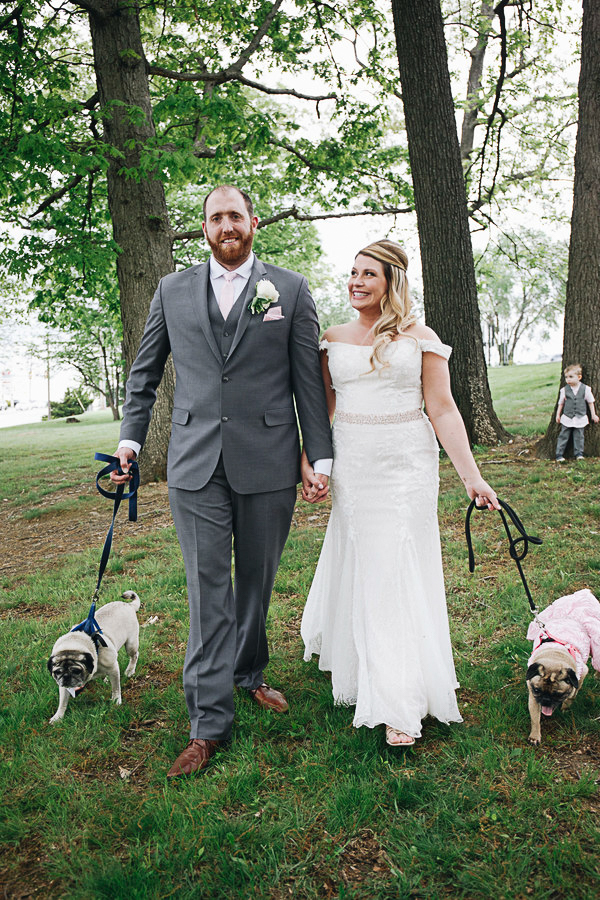 bride and groom walking with their Pugs in Park | ©Please Don't Blink Photography